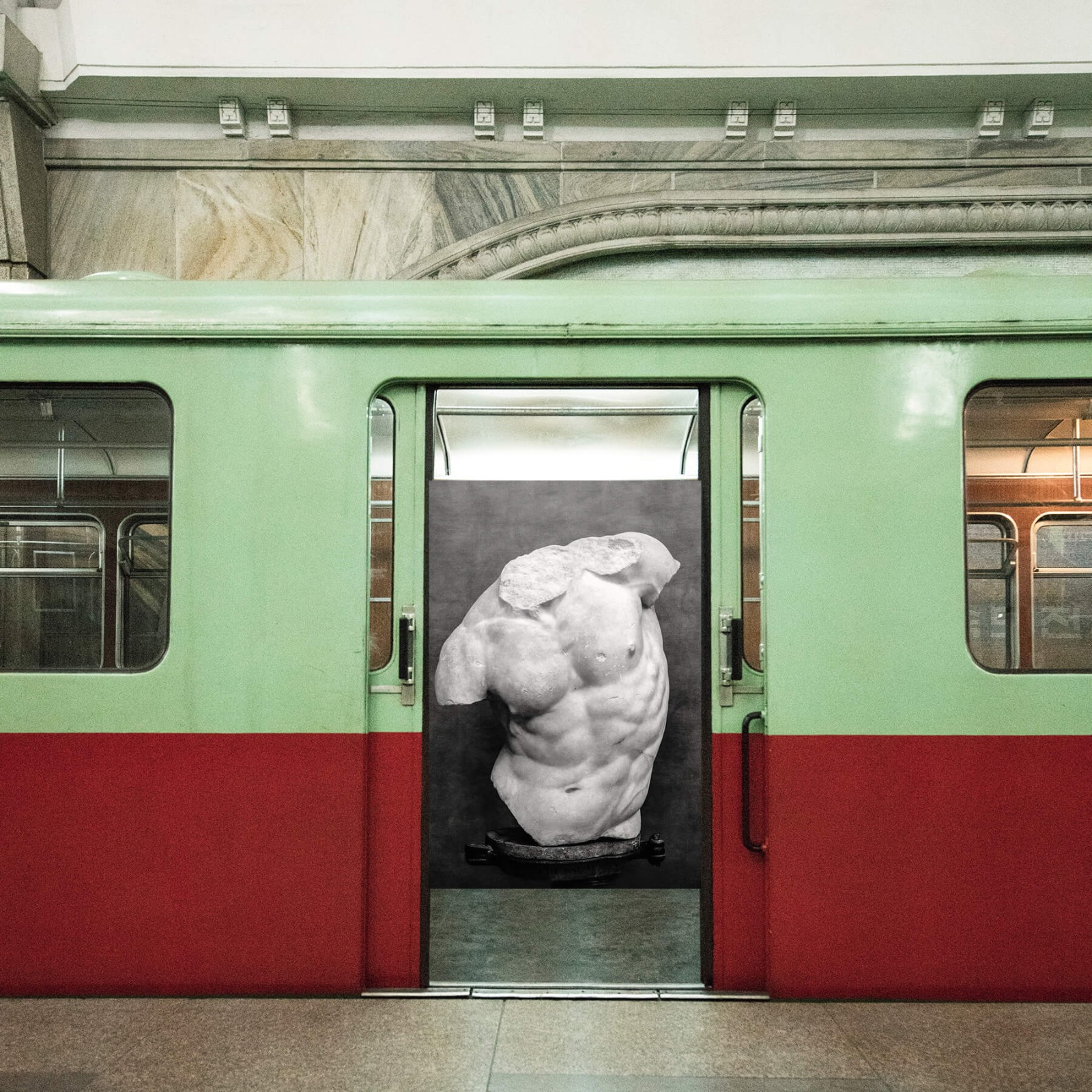 vagón de metro y escultura de torso griego