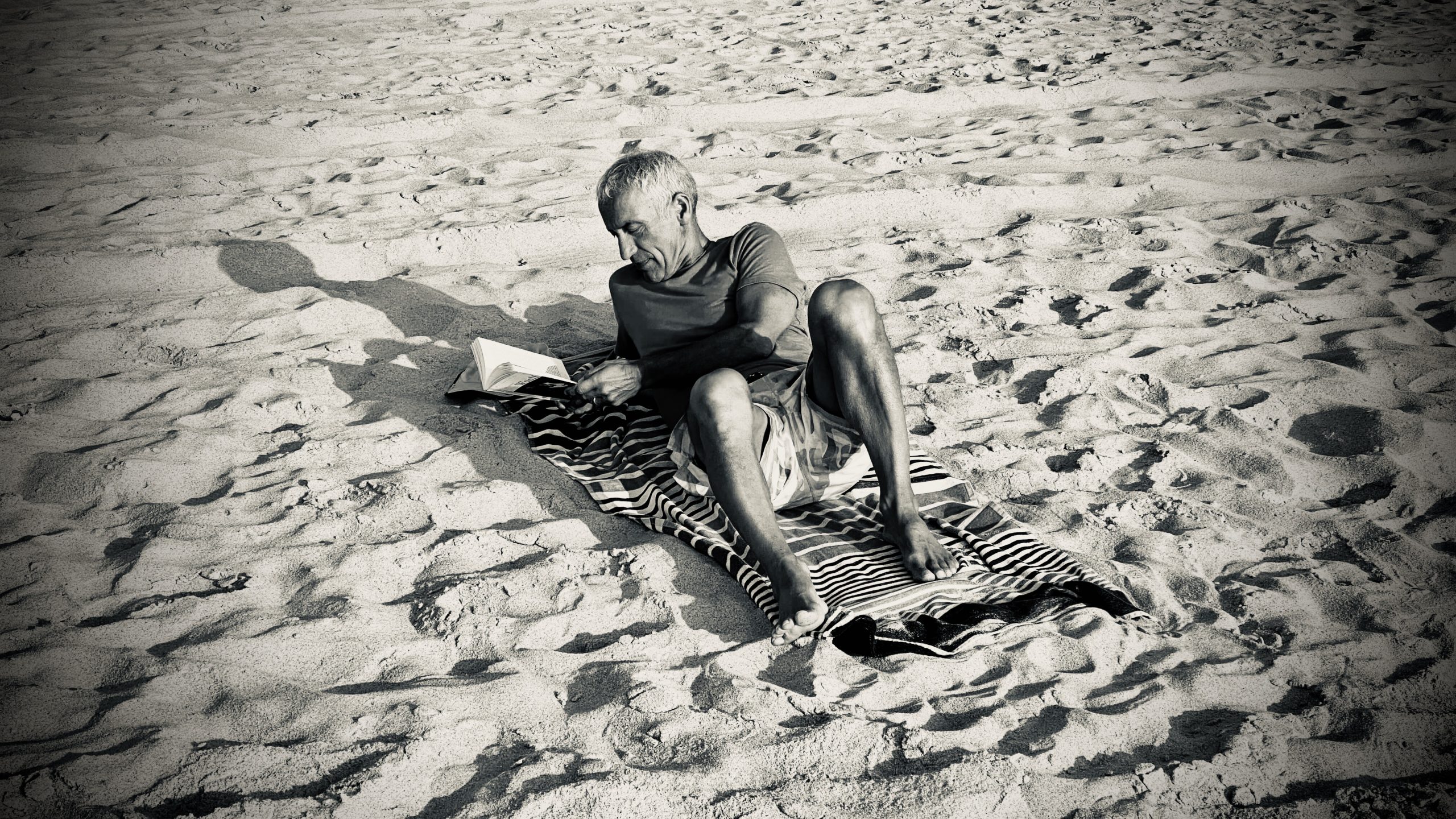 hombre leyendo en la playa