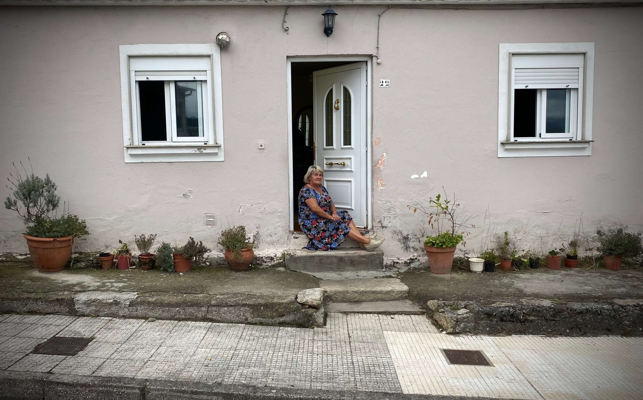 gallega sentada a la puerta de casa