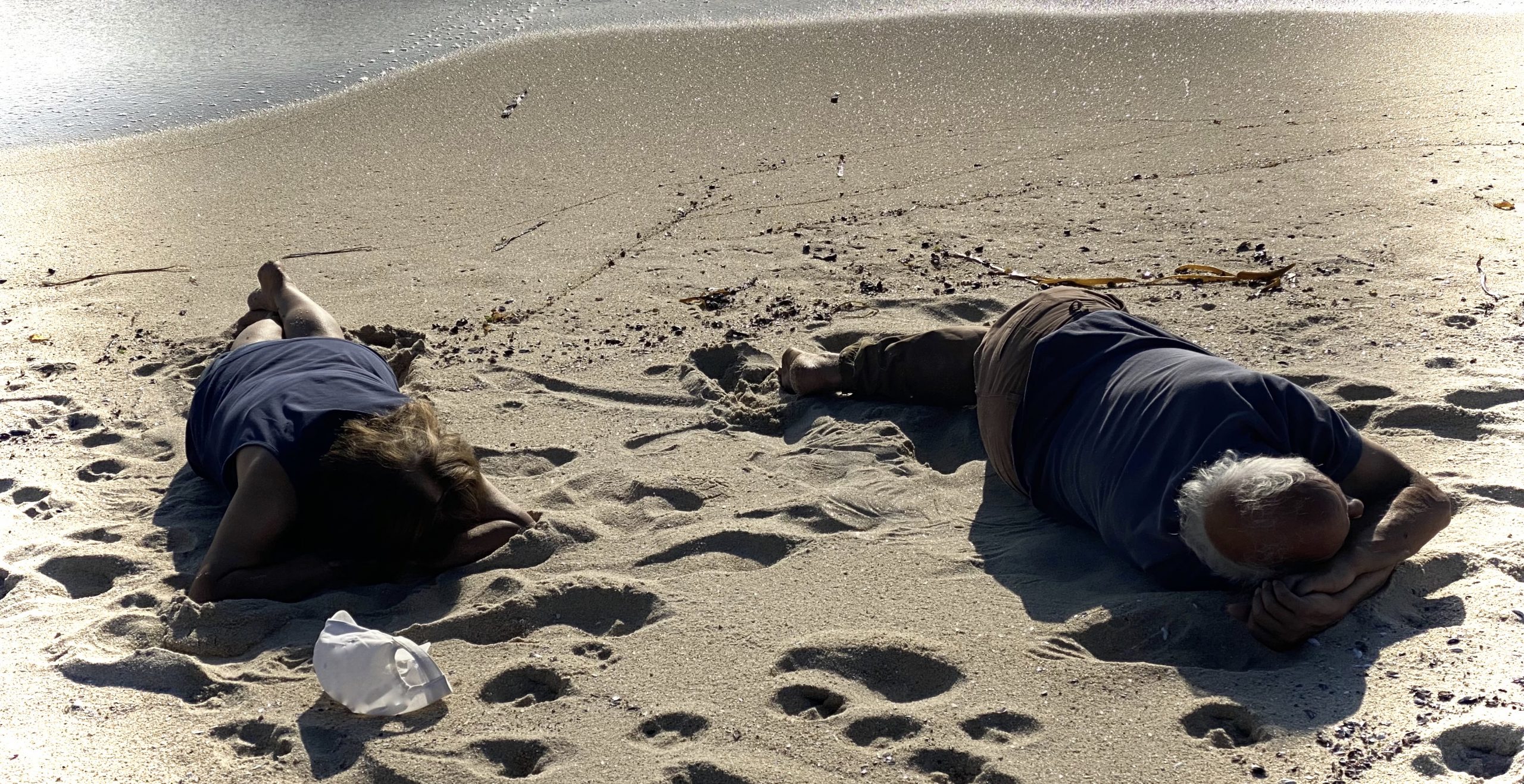 hombre y mujer durmiendo a la orilla del mar