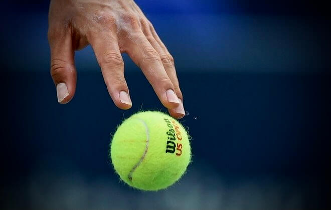 mano votando bola de tenis